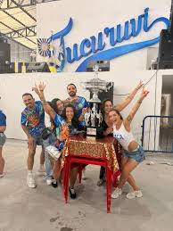 Rainha de bateria Carla Prata comemora campeonato do Tucuruvi com troféu na quadra 17 Carla Prata ladeada de sua equipe - Crédito da Foto: Renato Cipriano - Divulgação